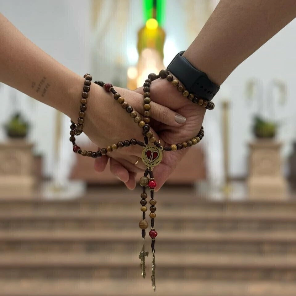 Mãos unidas com o Terço do Casal e o crucifixo